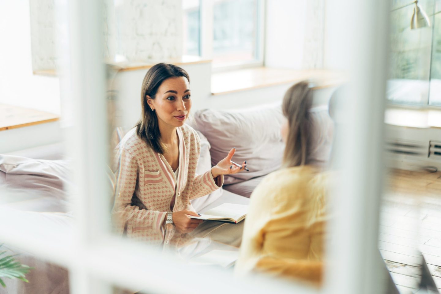 Two women sitting in armchairs and talking.