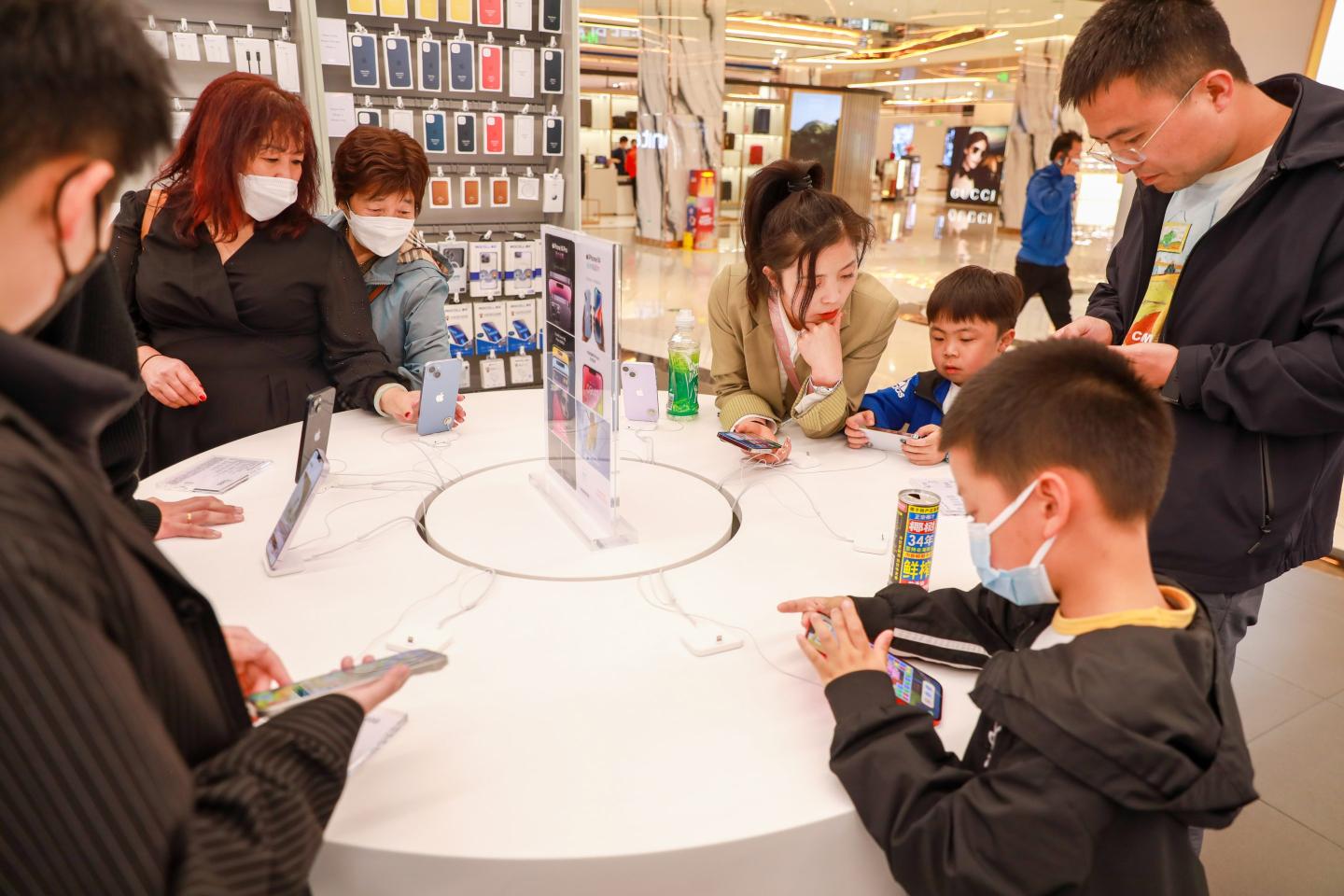 Chinese shoppers gather around an iPhone stand in China.
