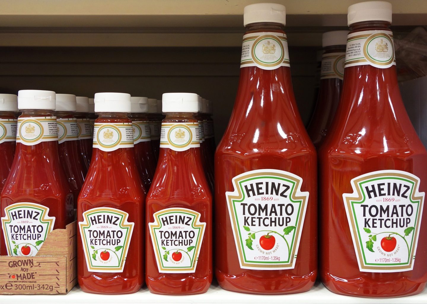 Bottles of Heinz tomato ketchup pictured on the shelves of a grocery store.