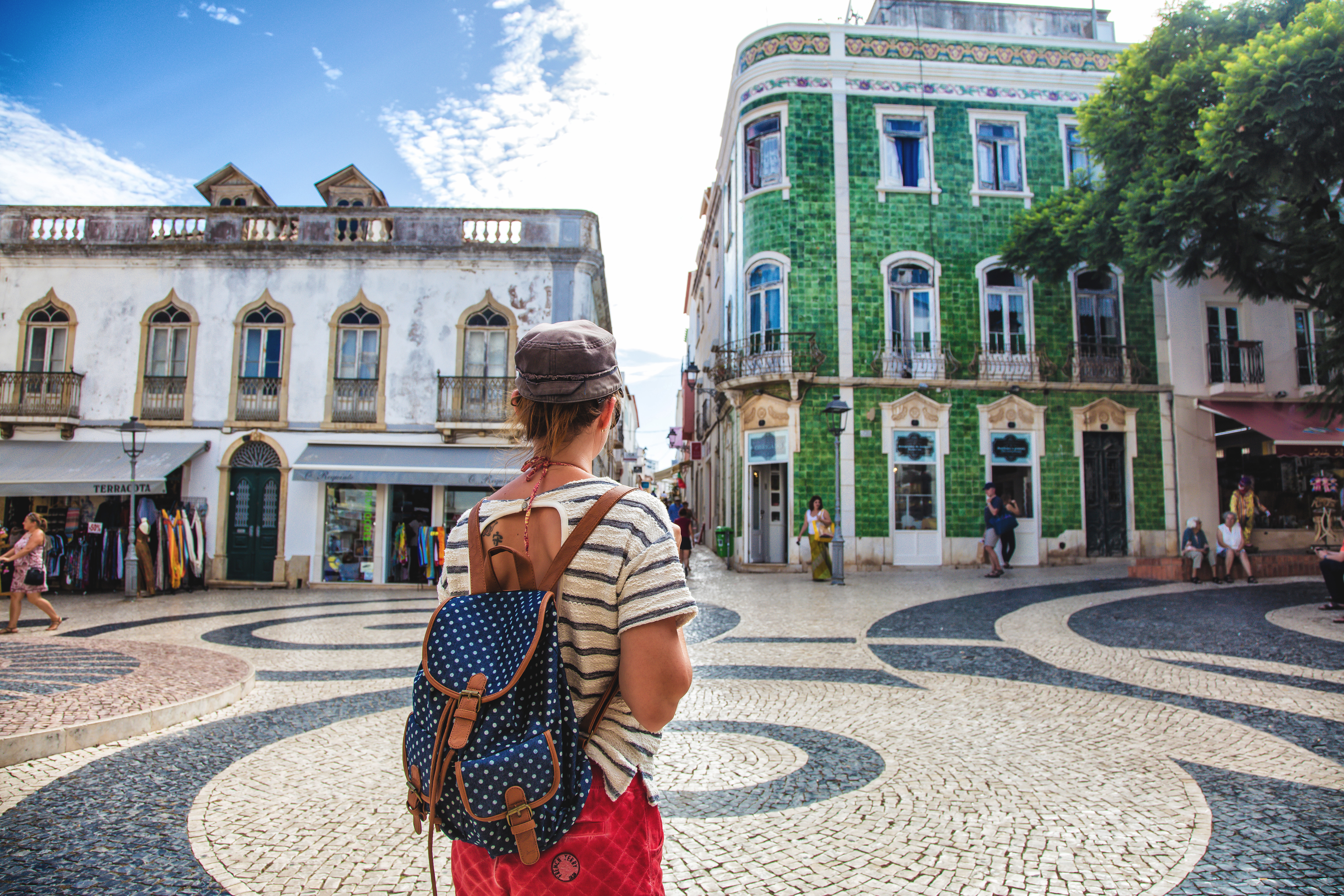 Young woman from behind, observed the square of the town of Burgau, Algarve region, Portugal