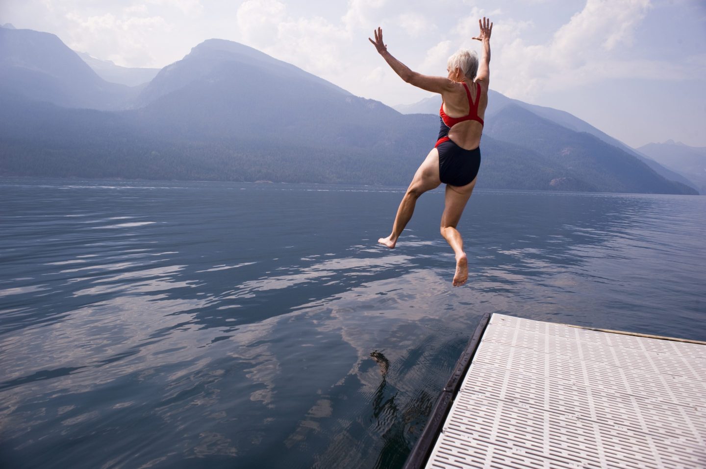 older woman jumoing into a lake