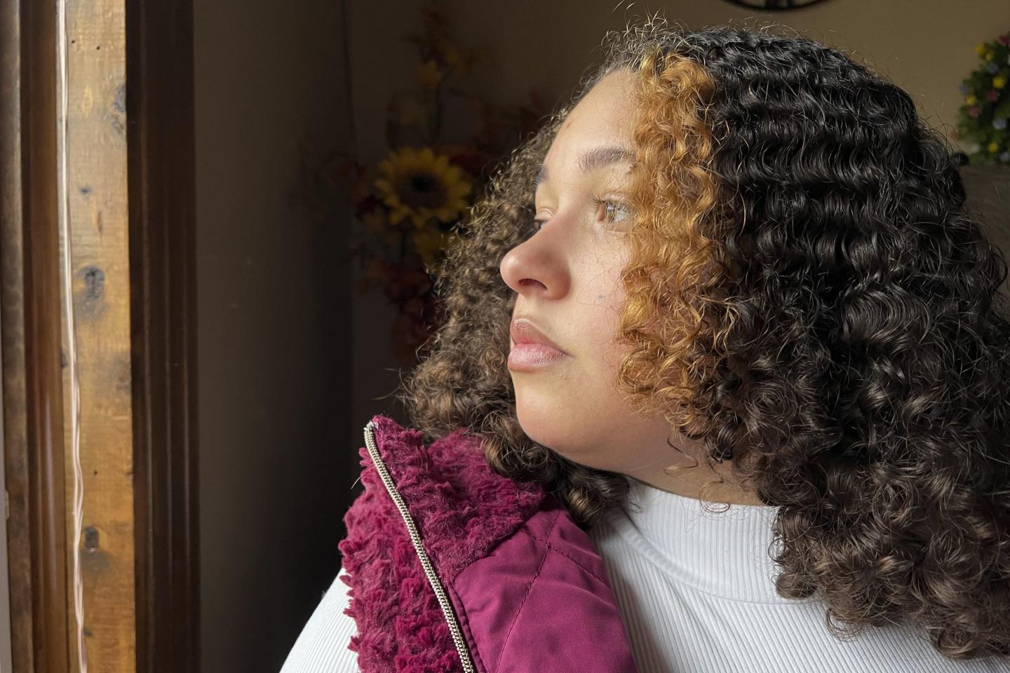 Mia Woodard looks out of a window at her grandmother's home on Feb. 1, 2023 in Jackson, Tenn. Woodard is among hundreds of thousands of Americans who came of age during the pandemic but didn't go to college. She hoped to be the first in her family to get a college degree, but in her senior year, she lost access to counselors and teachers who usually help students navigate college applications.