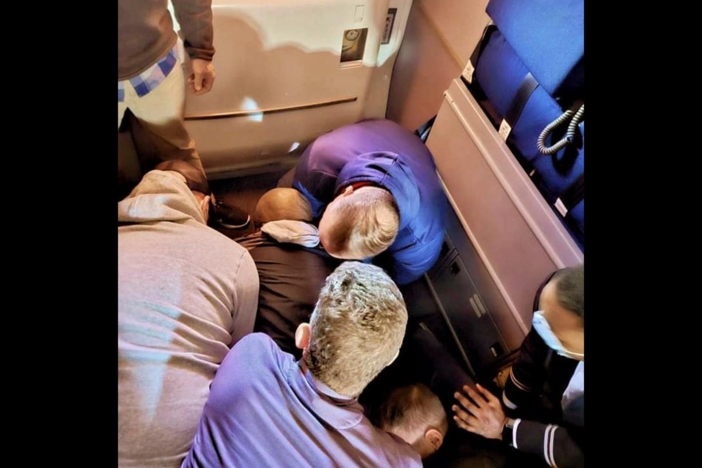 A group of airplane passengers zip-tied a man who tried to stab a flight attendant with a broken spoon: ‘Total teamwork’