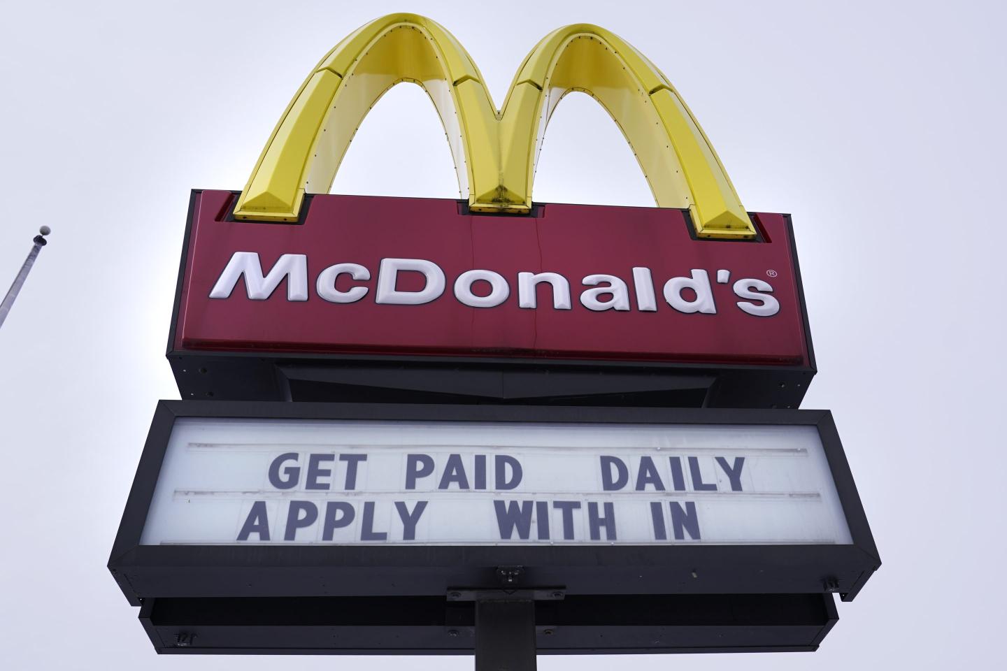 A sign outside a McDonald's restaurant offers prospective workers an opportunity to get paid daily for their employment, Monday, Feb. 27, 2023, in Salem, N.H.