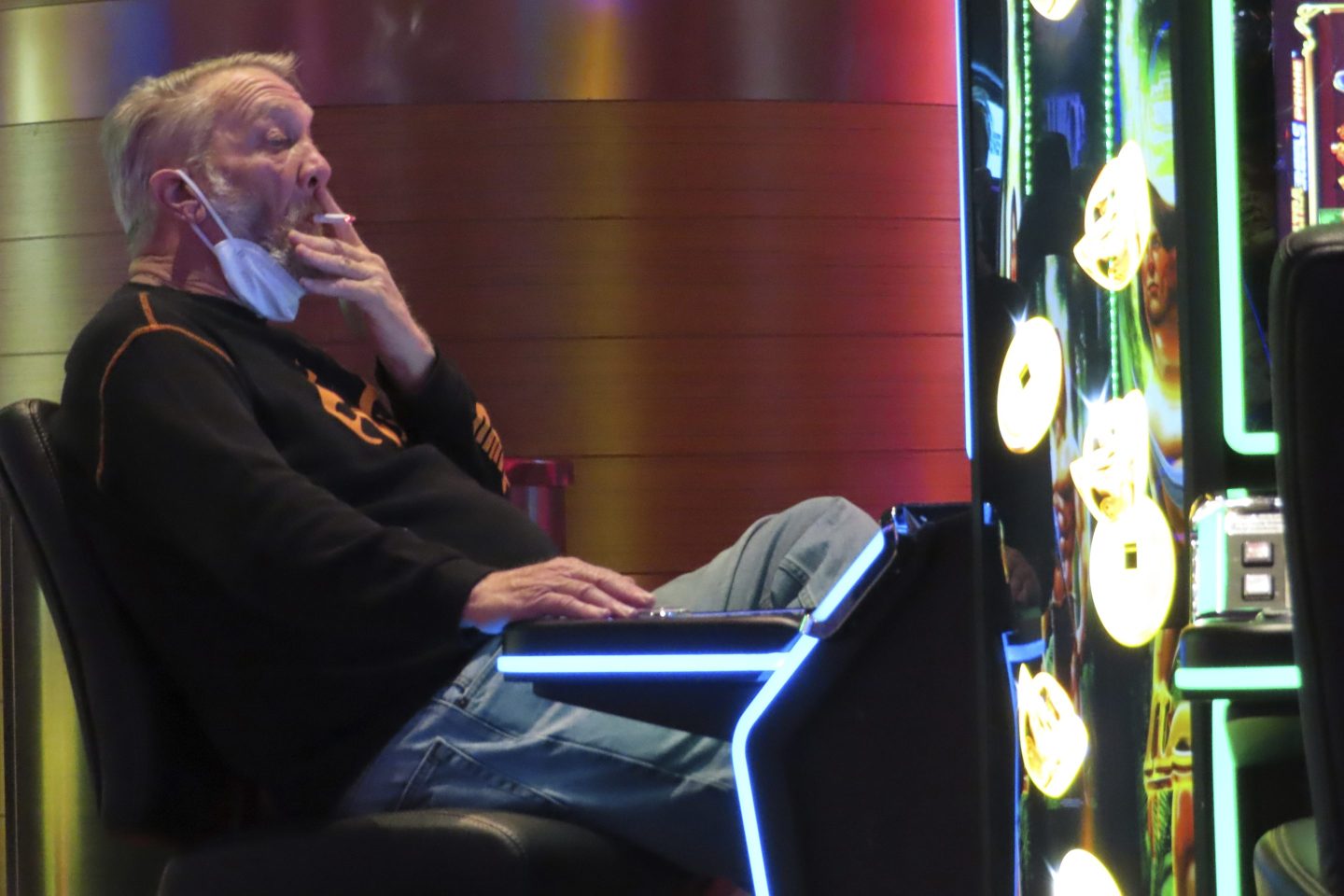 A gambler plays a slot machine while smoking in the Ocean Casino Resort in Atlantic City N.J. on Feb. 10, 2022. 