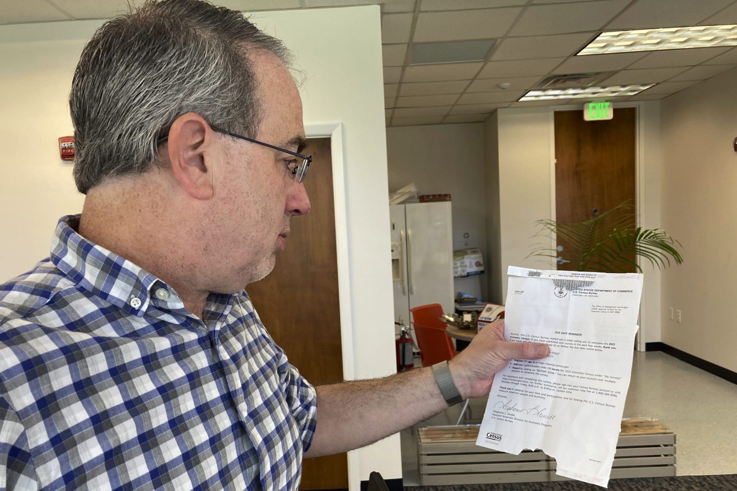 Erik Paul reads a notice from the U.S. Census Bureau reminding his software development firm to complete the 2022 Economic Census in Orlando, on March 24, 2023.