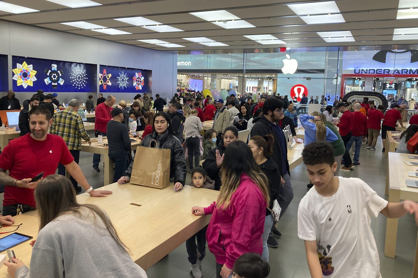 People shop at an Apple store in the Westfield Garden State Plaza mall in Paramus, New Jersey, on Saturday, December 17, 2022.