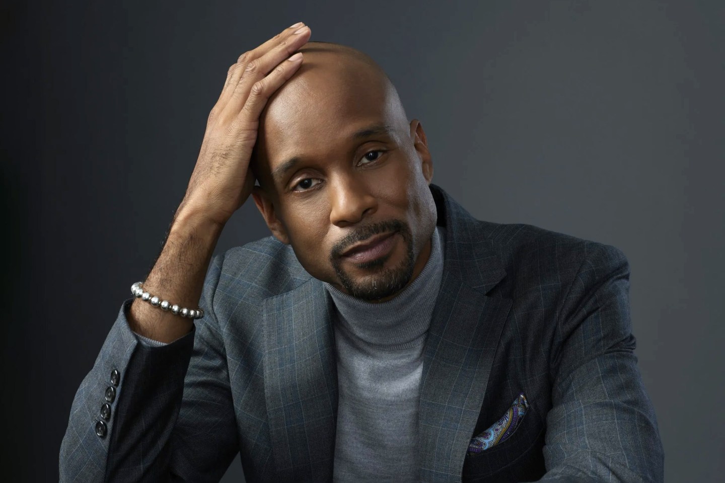 Portrait of Bomani Jones on gray background.