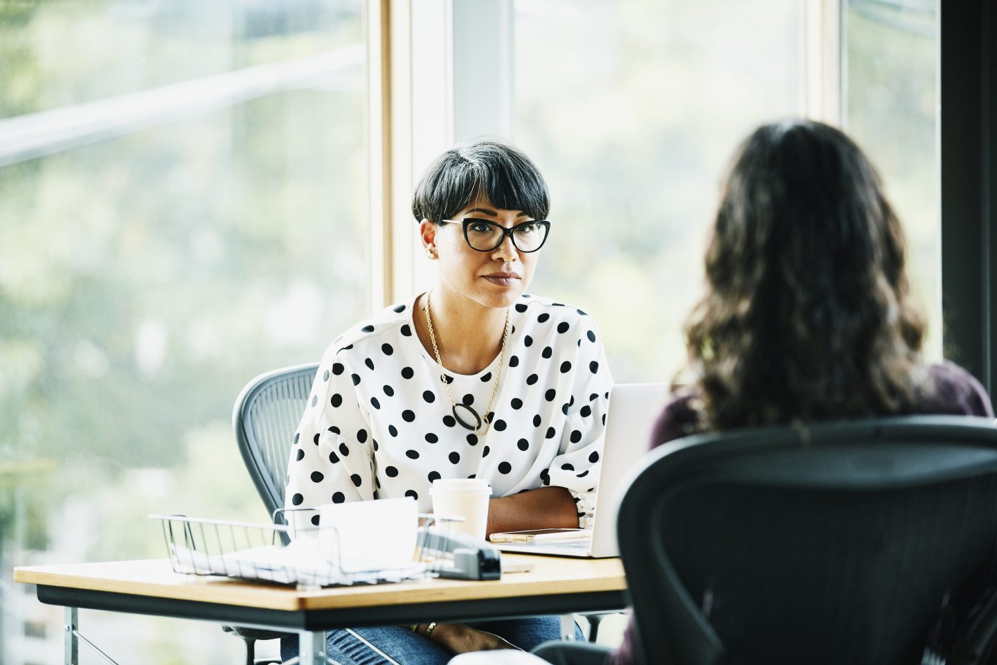 Mature businesswoman in discussion with employee while seated in the office