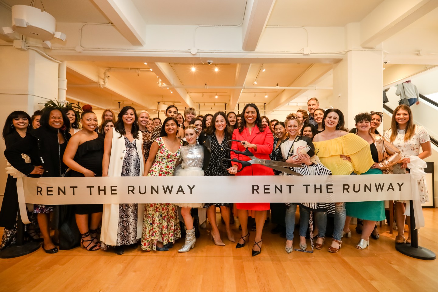 Chief Operating Officer Maureen Sullivan (center, in polka dots) and San Francisco Mayor London Breed (center in red) cut the ceremonial ribbon with Rent the Runway staff and guests during the launch of Rent the Runway's West Coast flagship store on May 08, 2019 in San Francisco, California.