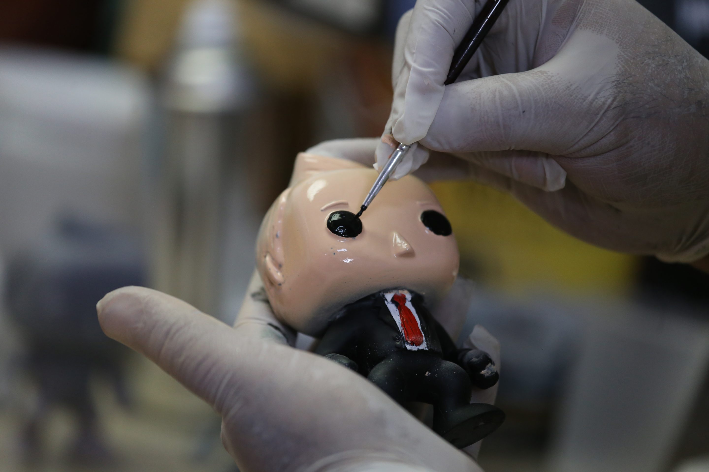 A Funko POP doll being painted.