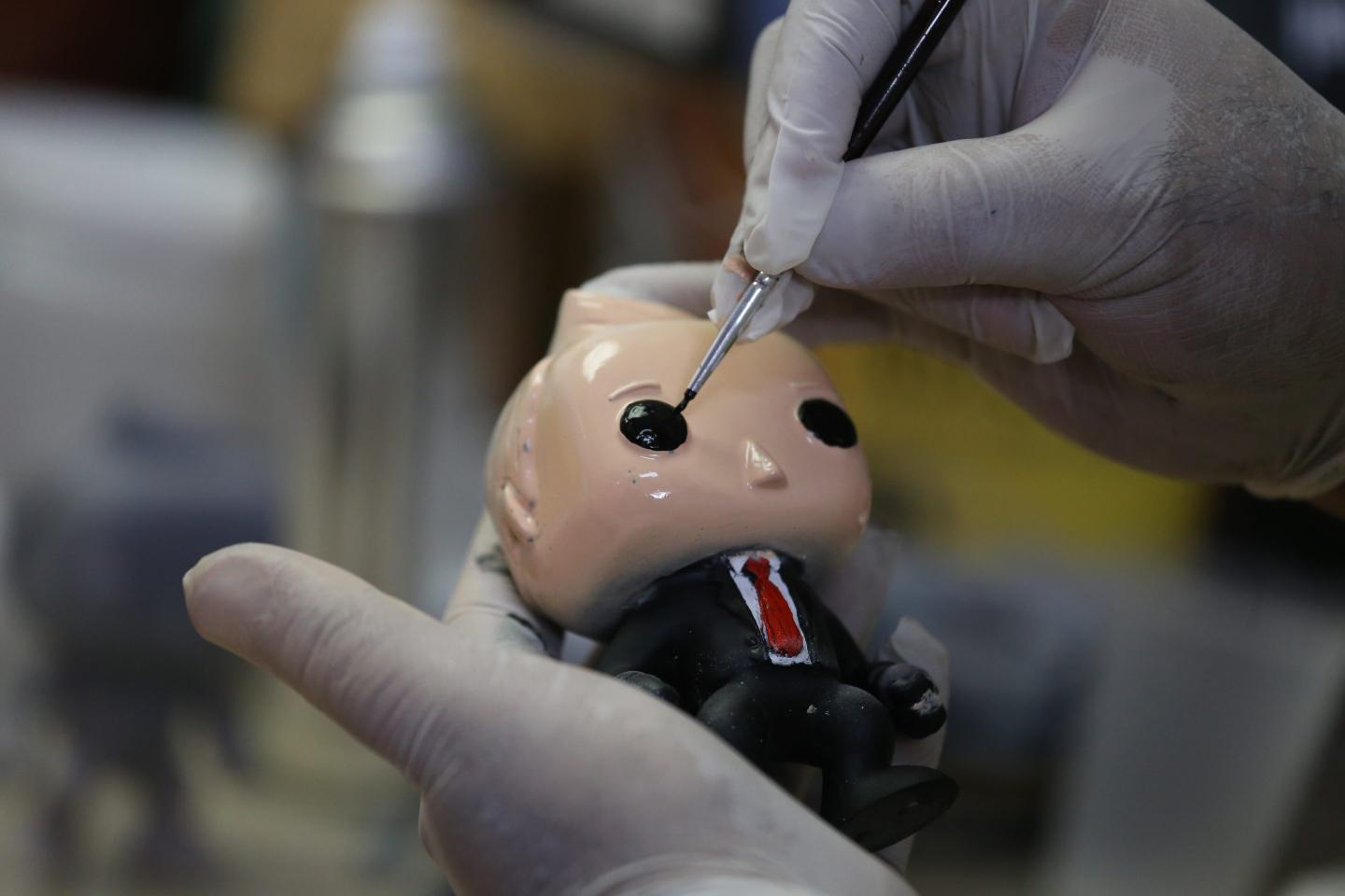 A Funko POP doll being painted.