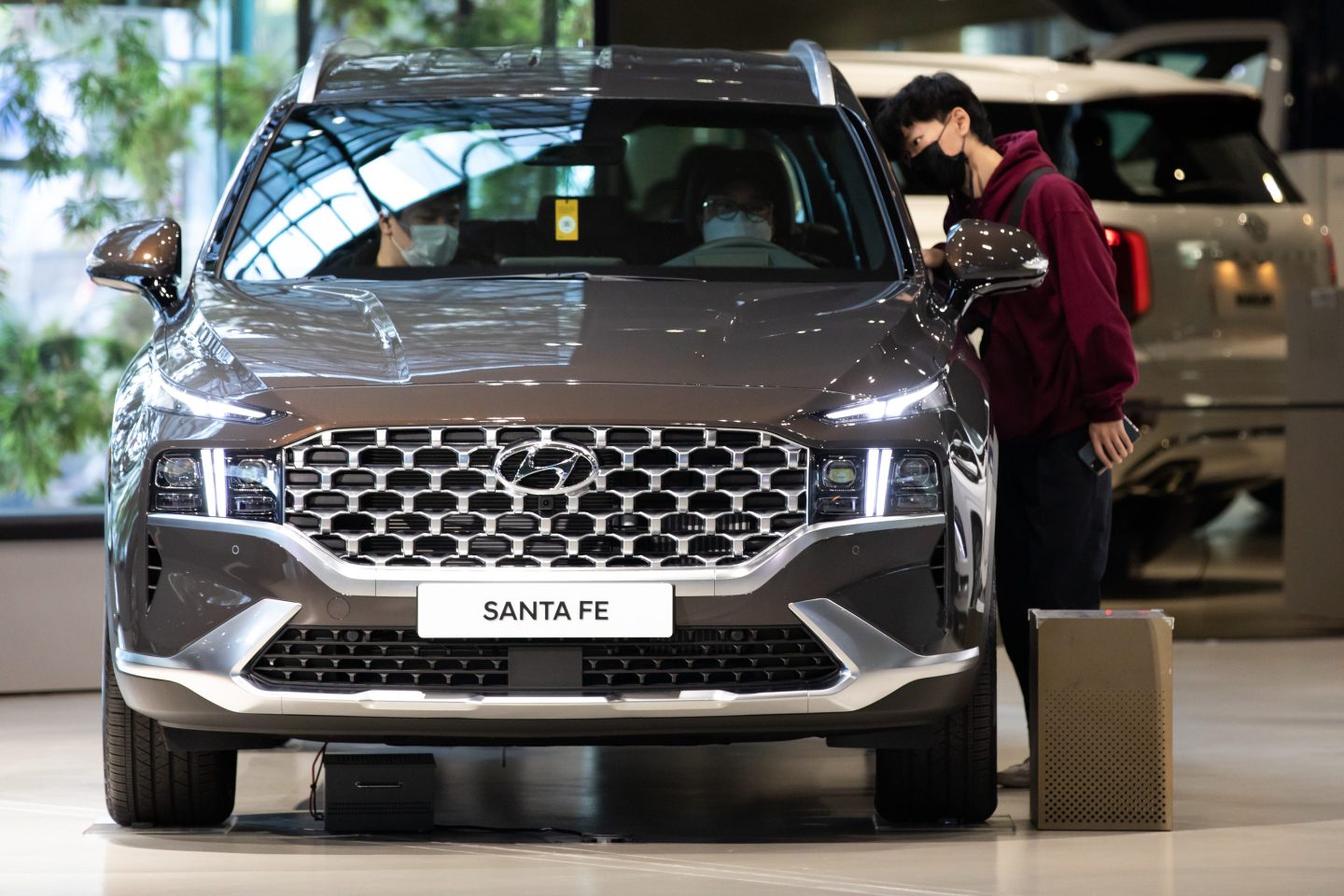 Customers wearing protective masks look inside a Hyundai Motor Co. Santa Fe