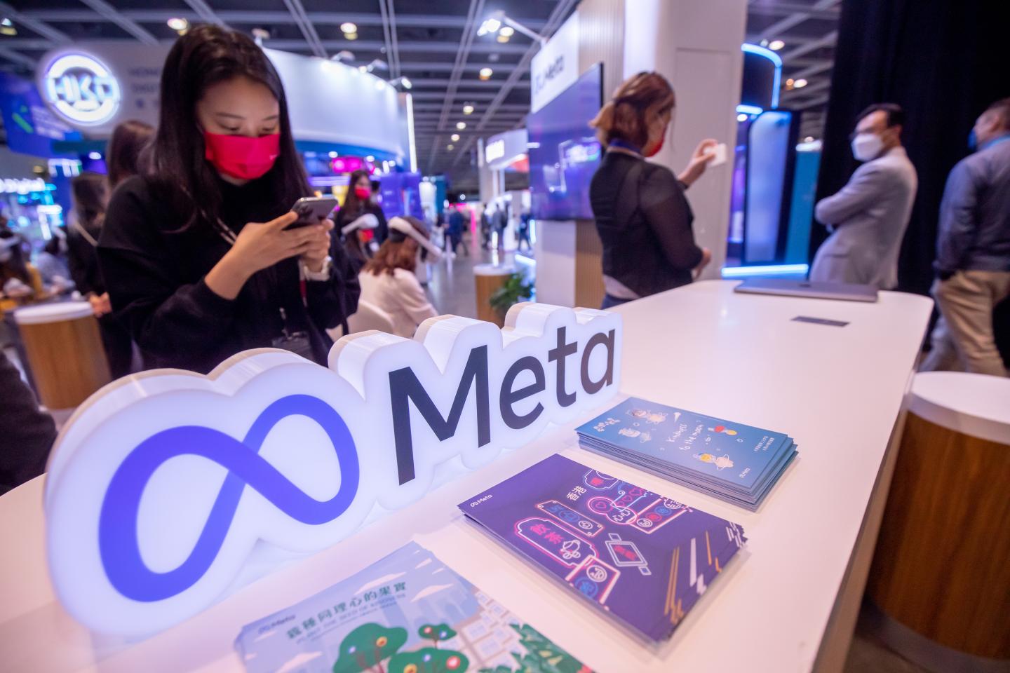 A person looks at their phone while standing at a booth.