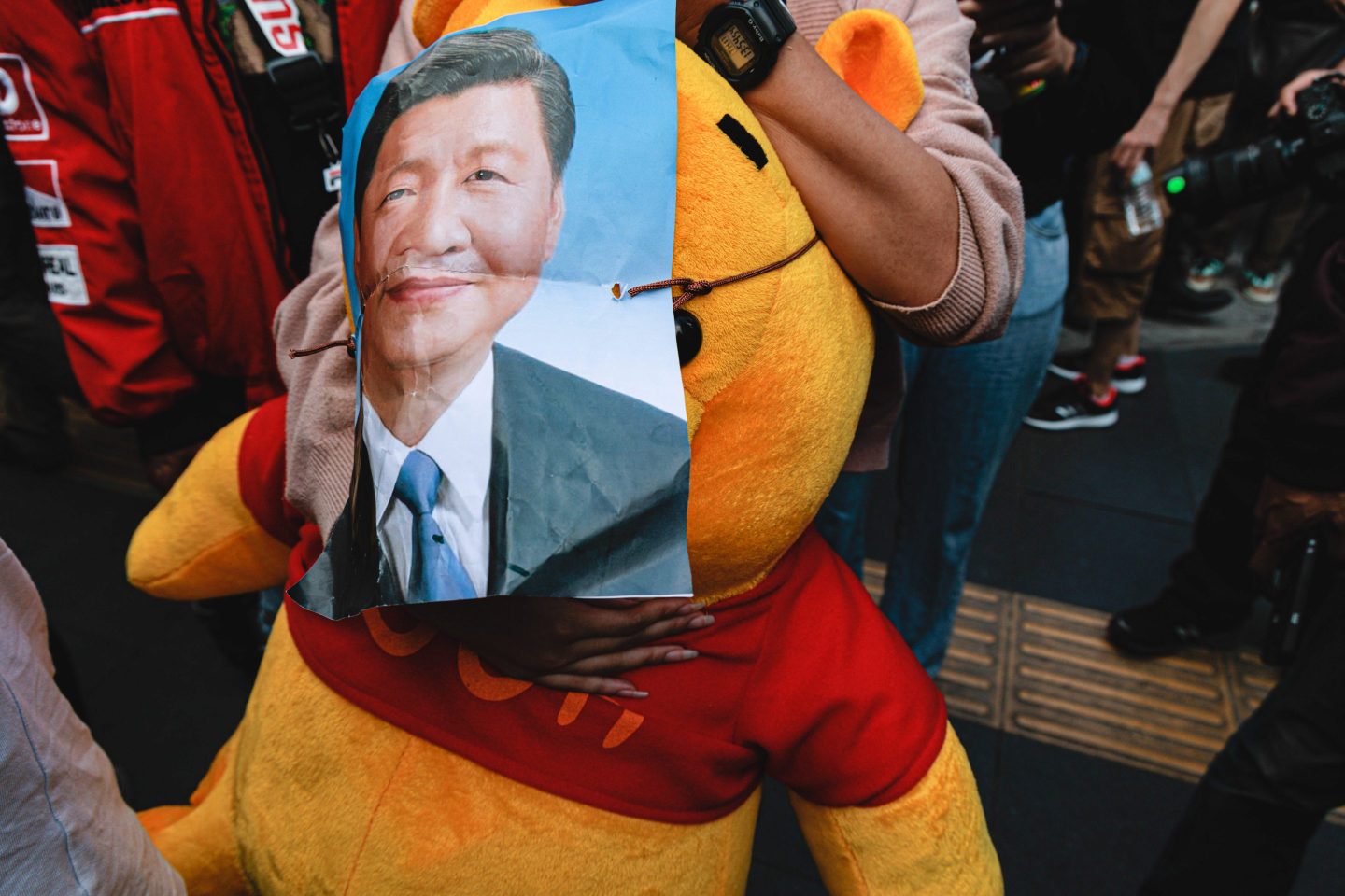 A pro-democracy protester holds a poster of China President Xi Jinping.