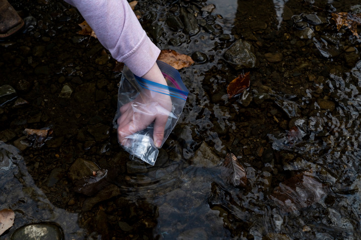 A person collects water samples following the Norfolk Southern train derailment in East Palestine, Ohio.