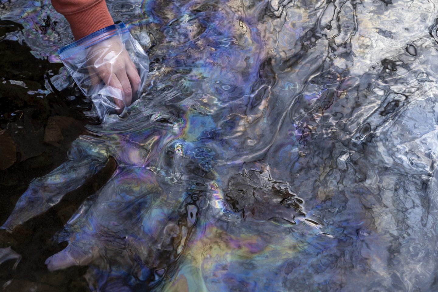 Olivia Holley, 22, and Taylor Gulish, 22, collect water samples from Leslie Run creek on February 25, 2023 in East Palestine, Ohio.