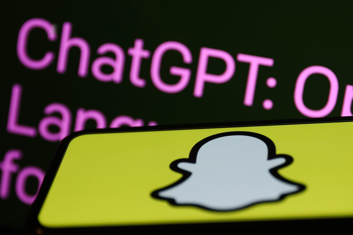 OpenAI ChatGPT website displayed on a laptop screen and Snapchat logo displayed on a phone screen