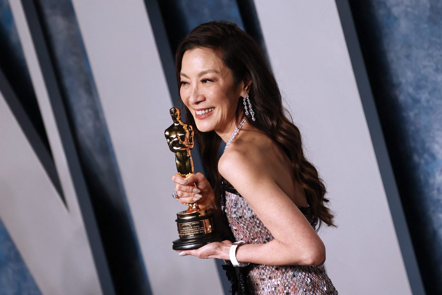 Michelle Yeoh holding her Oscar award