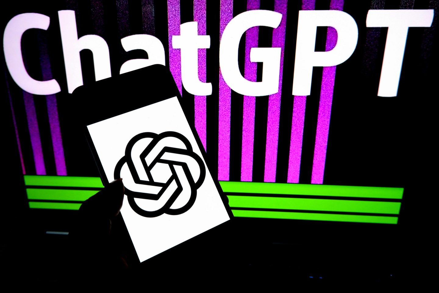 an Open AI logo is seen displayed on a smartphone with a ChatGPT writing in the background