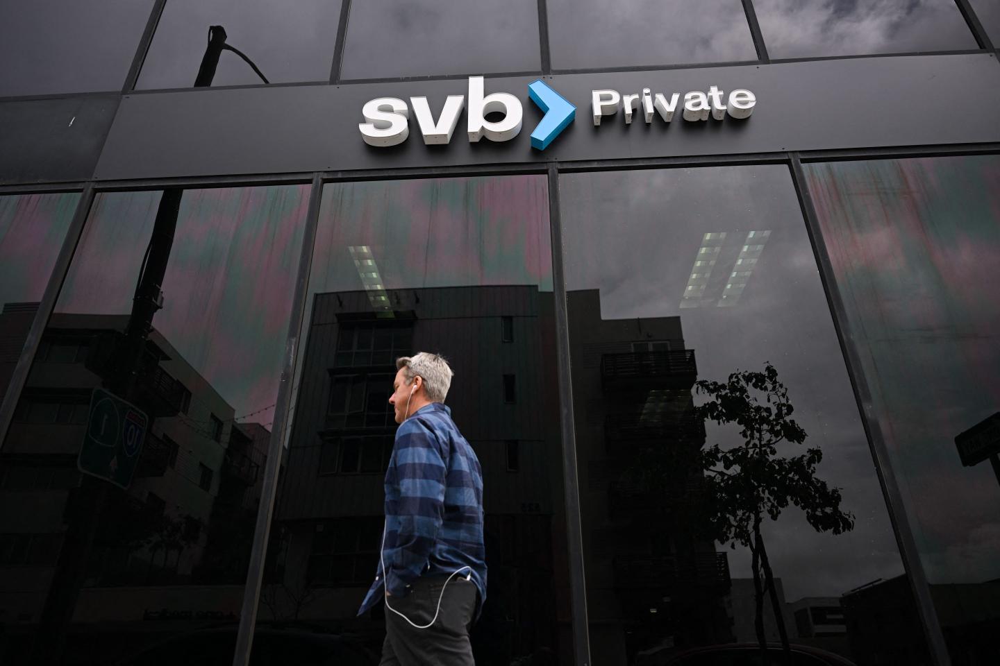 A person walks beneath a Silicon Valley Bank sign