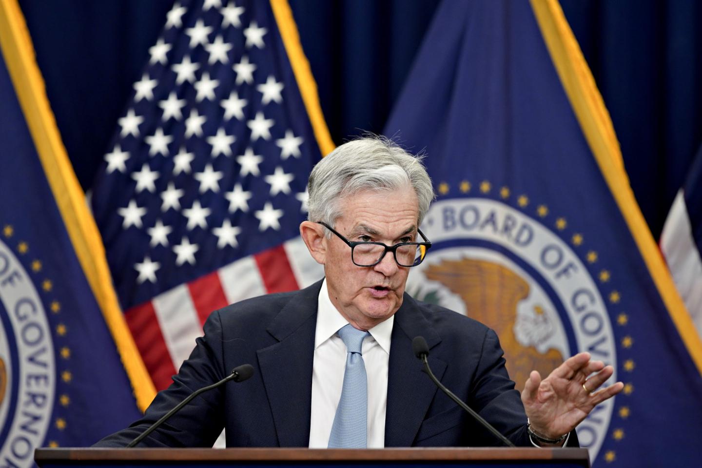 Fed Chair Jerome Powell stands in front of reporters at a news conference