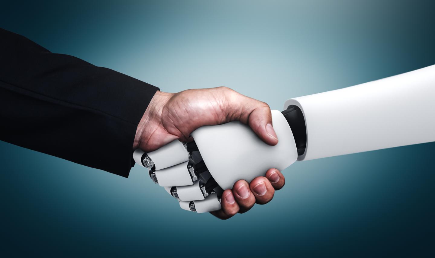 A human hand shaking a robot's hand