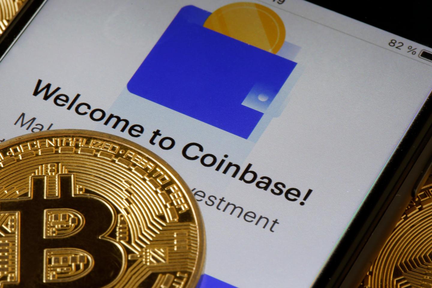 The Coinbase app is seen alongside a visual representation of the cryptocurrency Bitcoin.