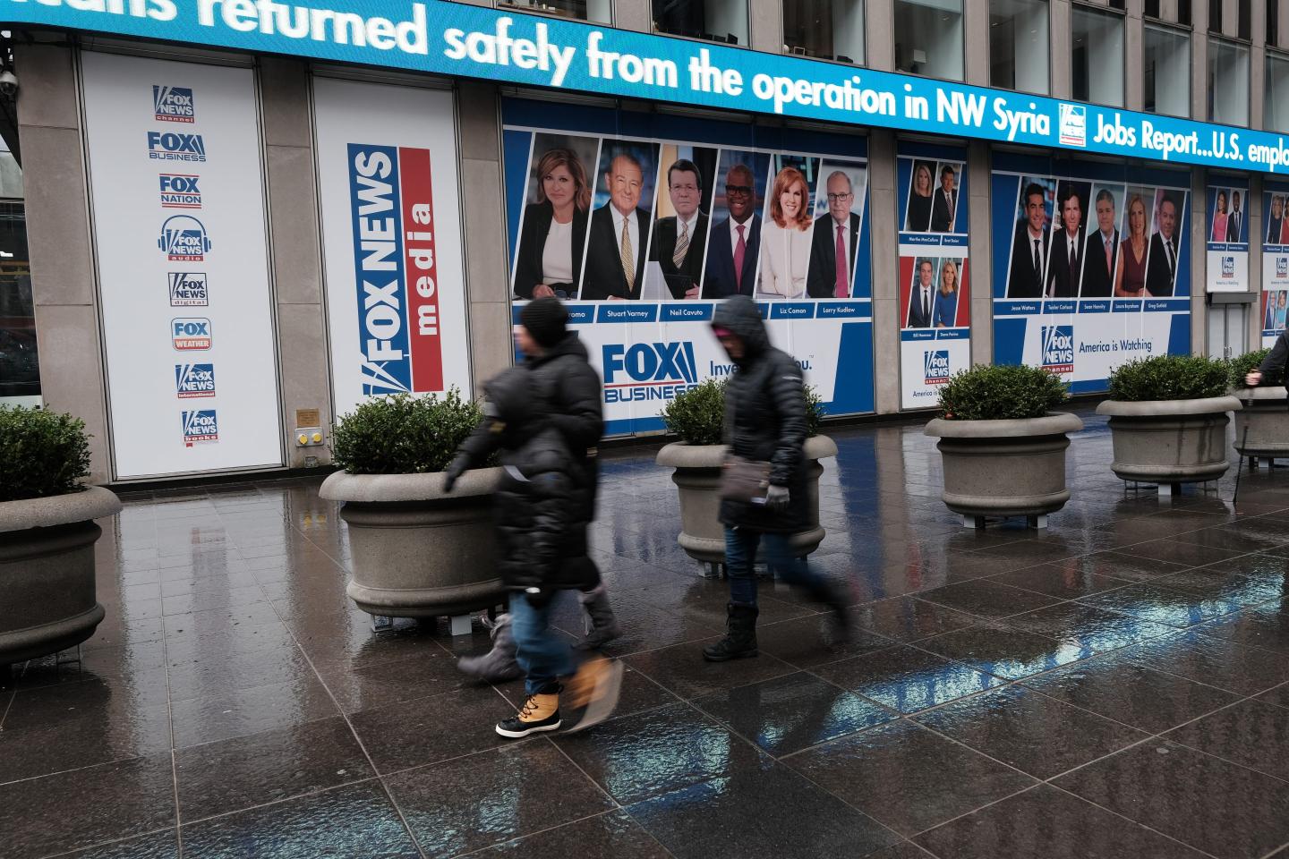 People walk past 1211 Avenue of the Americas the headquarters for News Corp