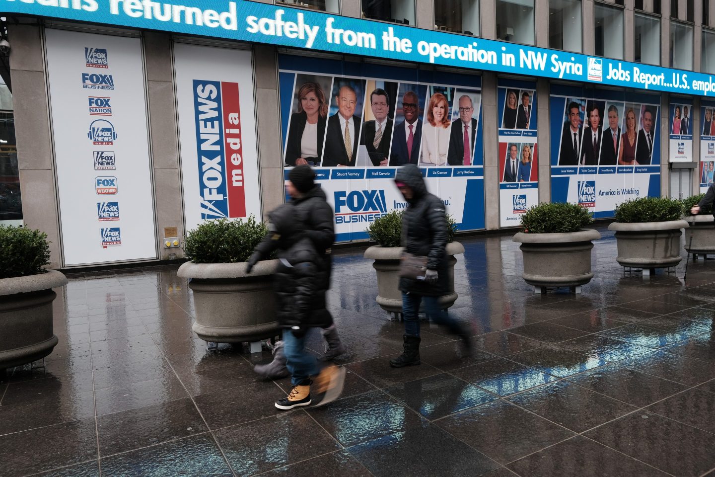 People walk past 1211 Avenue of the Americas the headquarters for News Corp