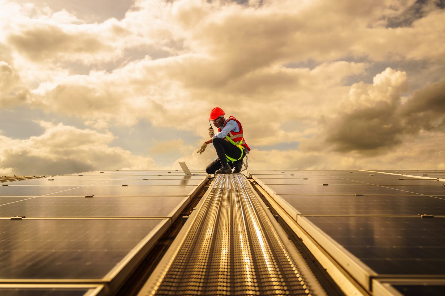 An engineer checks on some rooftop solar panels.
