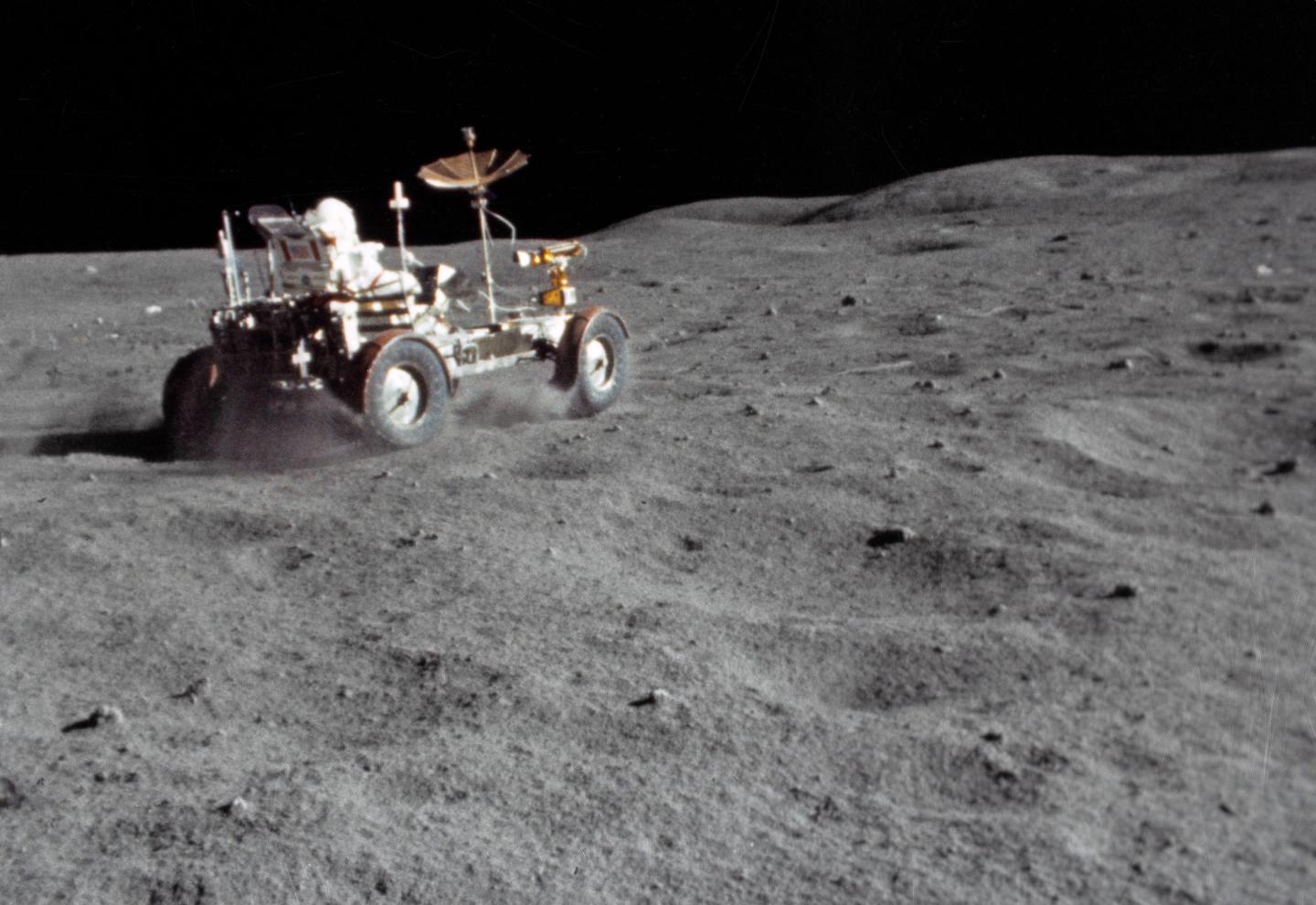 A rover on Moon's surface with an astronaut driving it