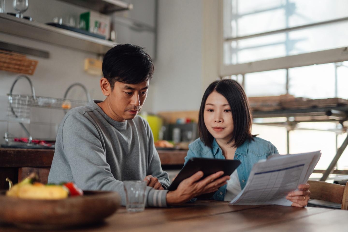 Asian couple planning home finance with digital tablet at home