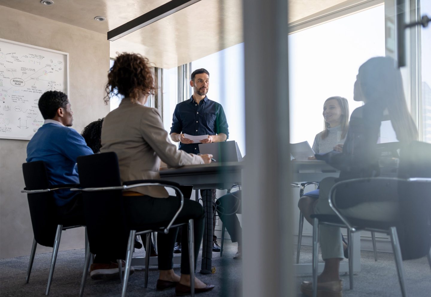 a group of employees in a glass conference room