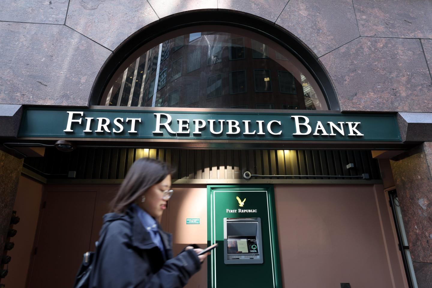 A pedestrian walks by a First Republic Bank office.