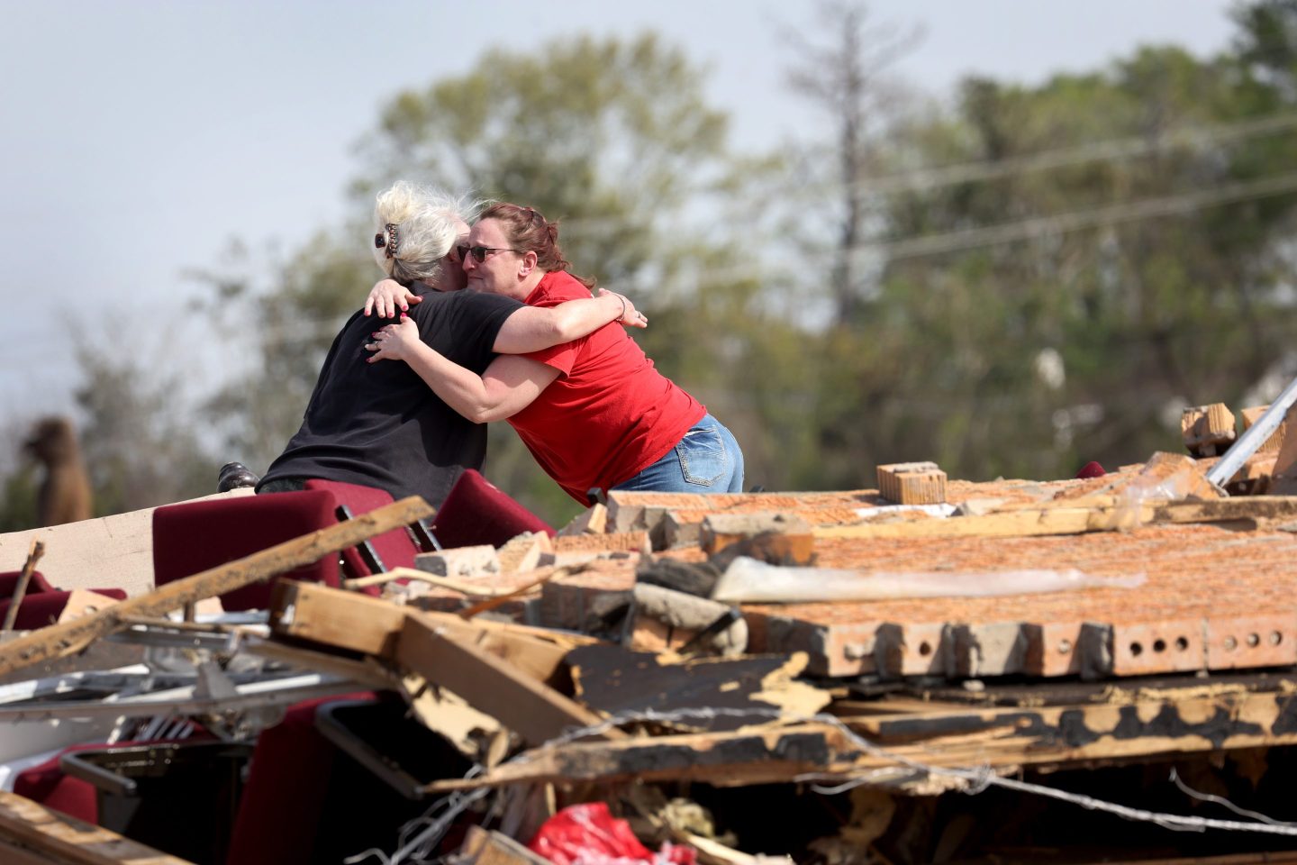 Two women hug among the rubble of a home as cleanup continues in the aftermath of the Mar. 28 tornado in Rolling Fork, Mississippi.