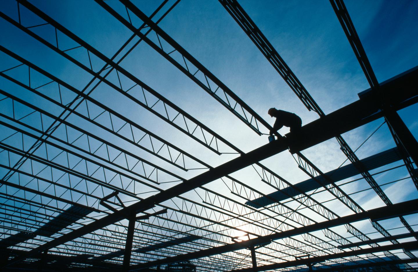 A construction worker on the roof of an unfinished building