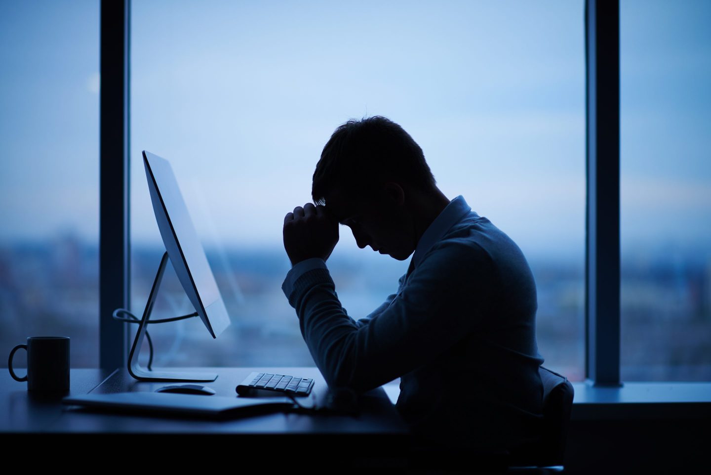 Tired or stressed businessman sitting in front of computer