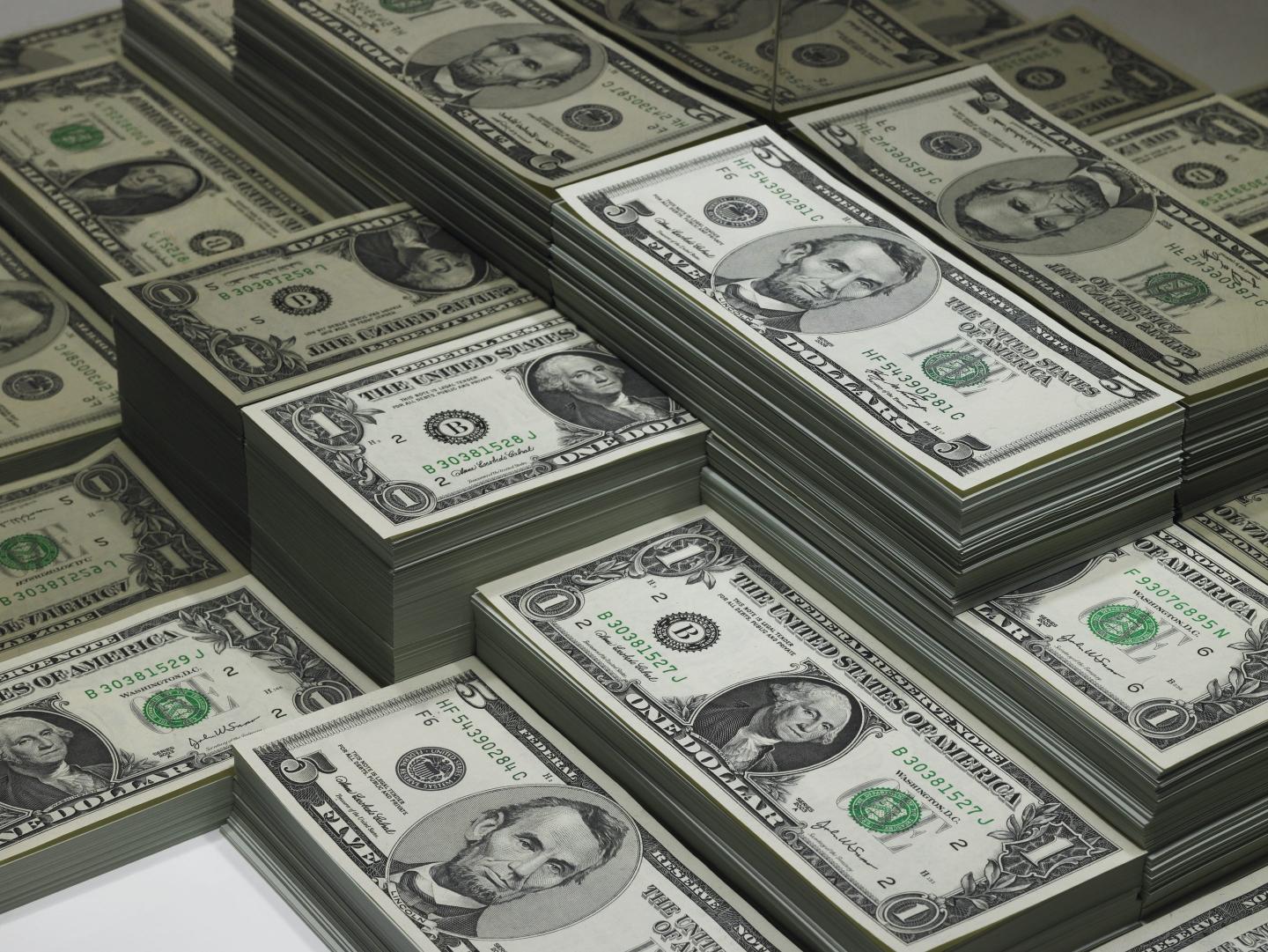 Piles of U.S. dollars are pictured.