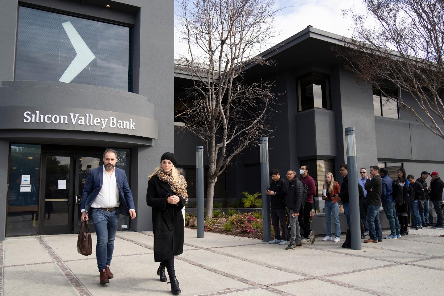 People queue up outside the headquarters of Silicon Valley Bank to withdraw their funds on March 13, 2023 in California.