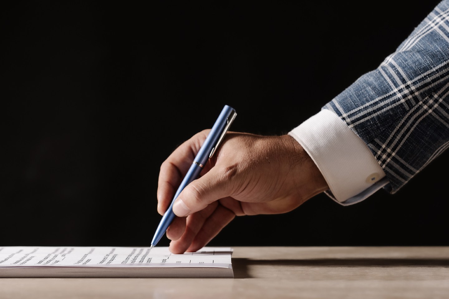 Businessman signing a contract on the table.