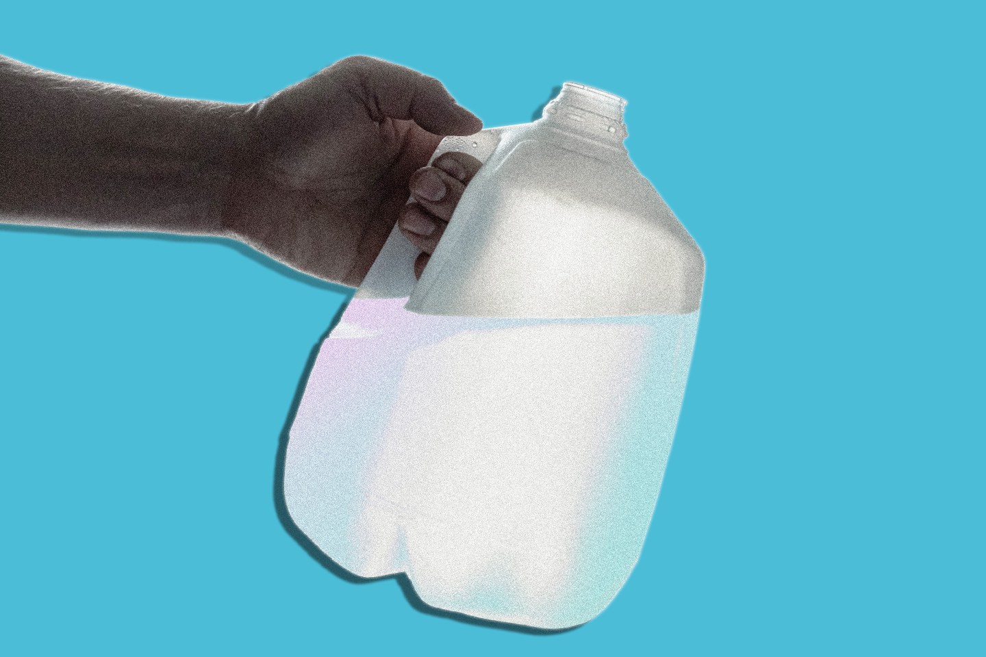 Hand holding a one-gallon plastic bottle