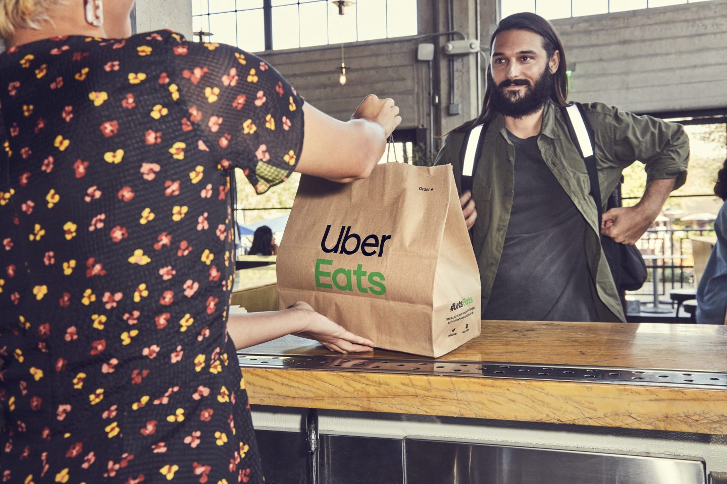Customer at a restaurant picks up his Uber Eats order
