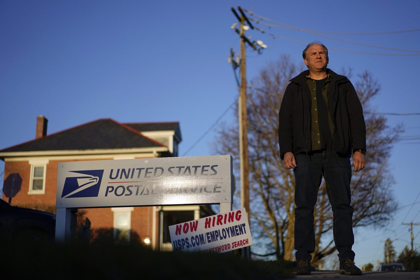 Gerald Groff, a former postal worker whose case will be argued before the Supreme Court, stands during a television interview near a "Now Hiring" sign posted at the roadside at the United State Postal Service, on March 8, 2023, in Quarryville, Pa.
