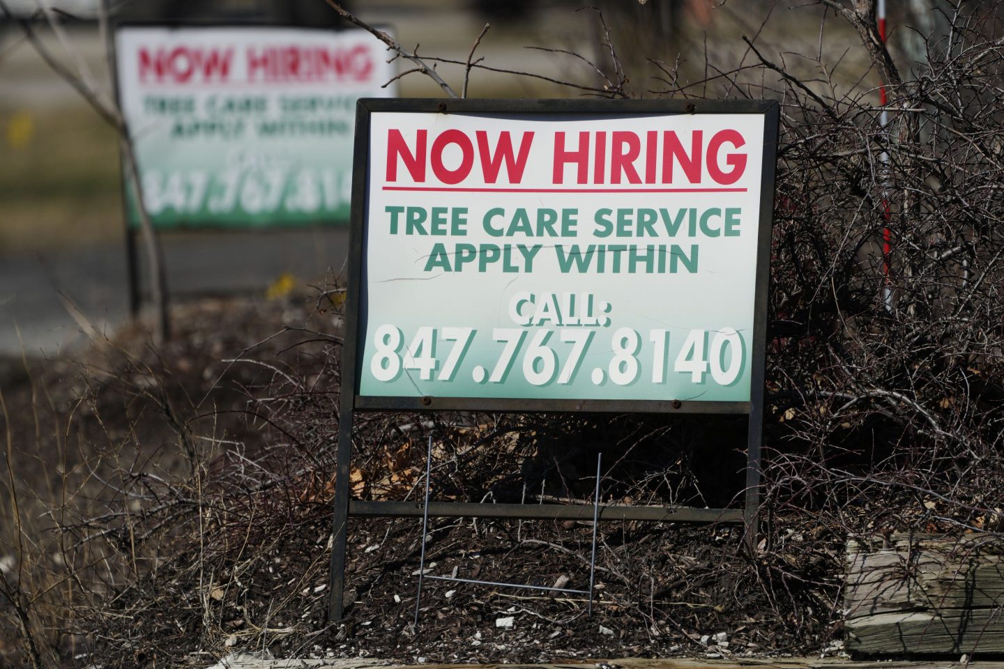 A hiring sign for tree care service work is posted in Wheeling, Ill., Sunday, March 19, 2023. 