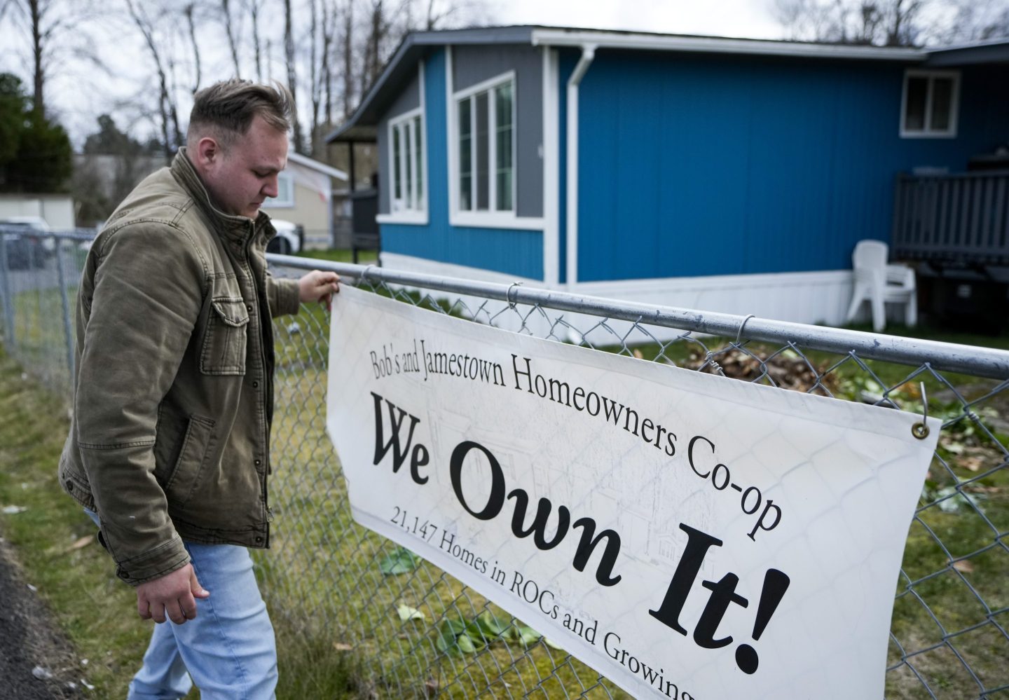 Gadiel Galvez adjusts a sign stating that his resident cooperative owns their mobile home park, Bob’s and Jamestown Homeowners Cooperative, in Lakewood, Wash. on March 25.