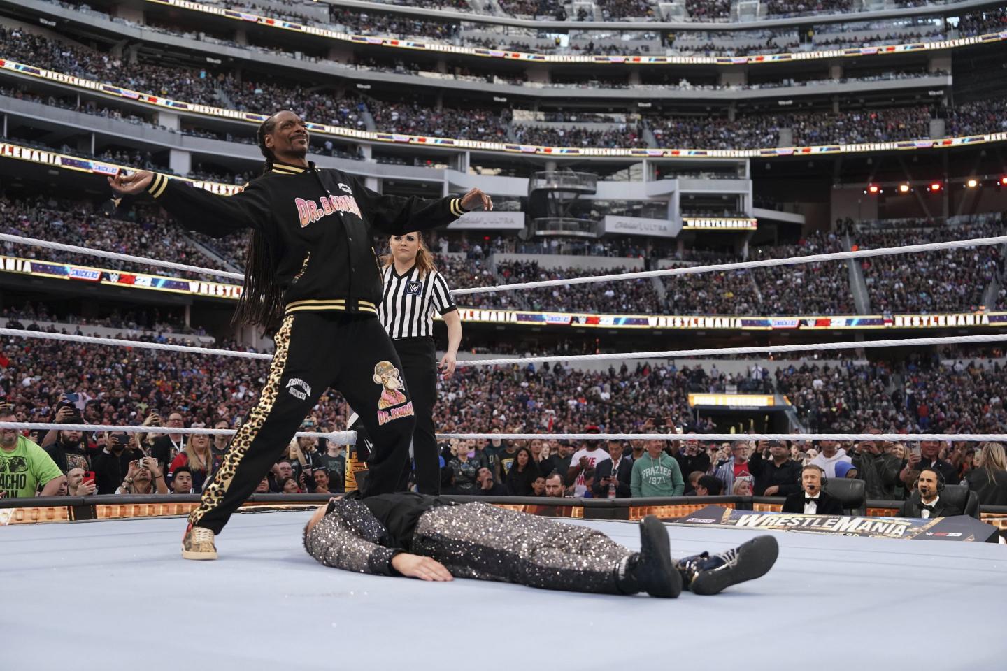 Rapper Snoop Dogg steps away from his hosting duties and enters the ring in record-setting WrestleMania