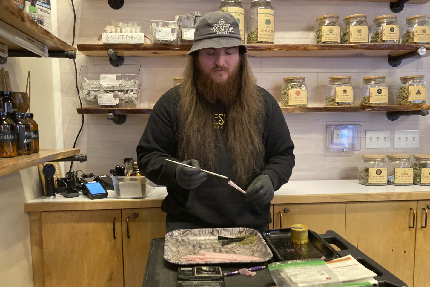 River Herber, an employee of Preserve Oregon, a marijuana shop in Salem, Oregon, rolls a joint on Jan. 31, 2023.