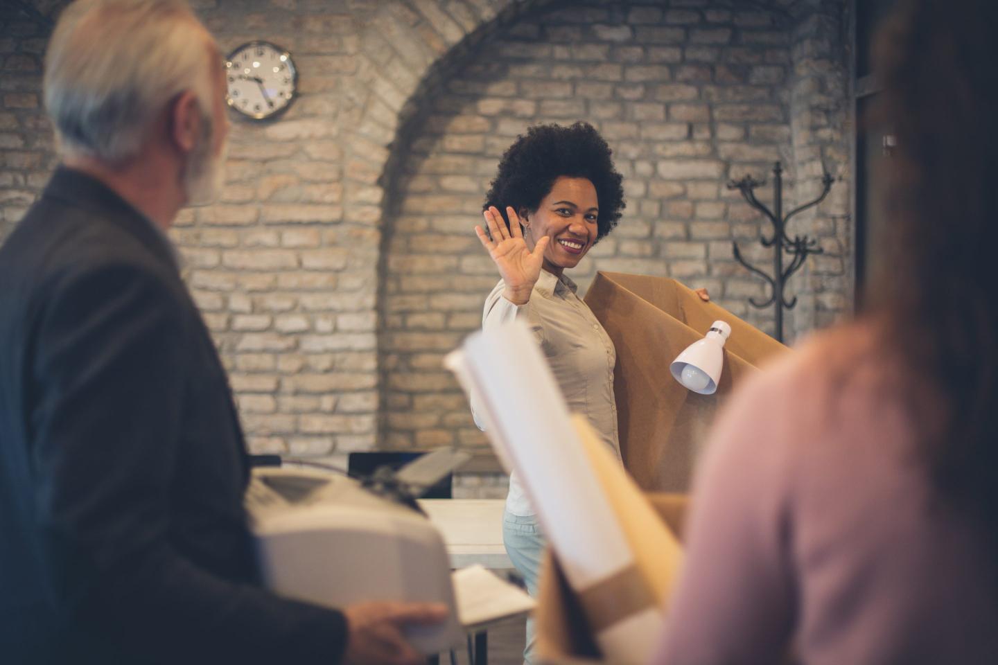 Woman smiling and waving as she quits her job.