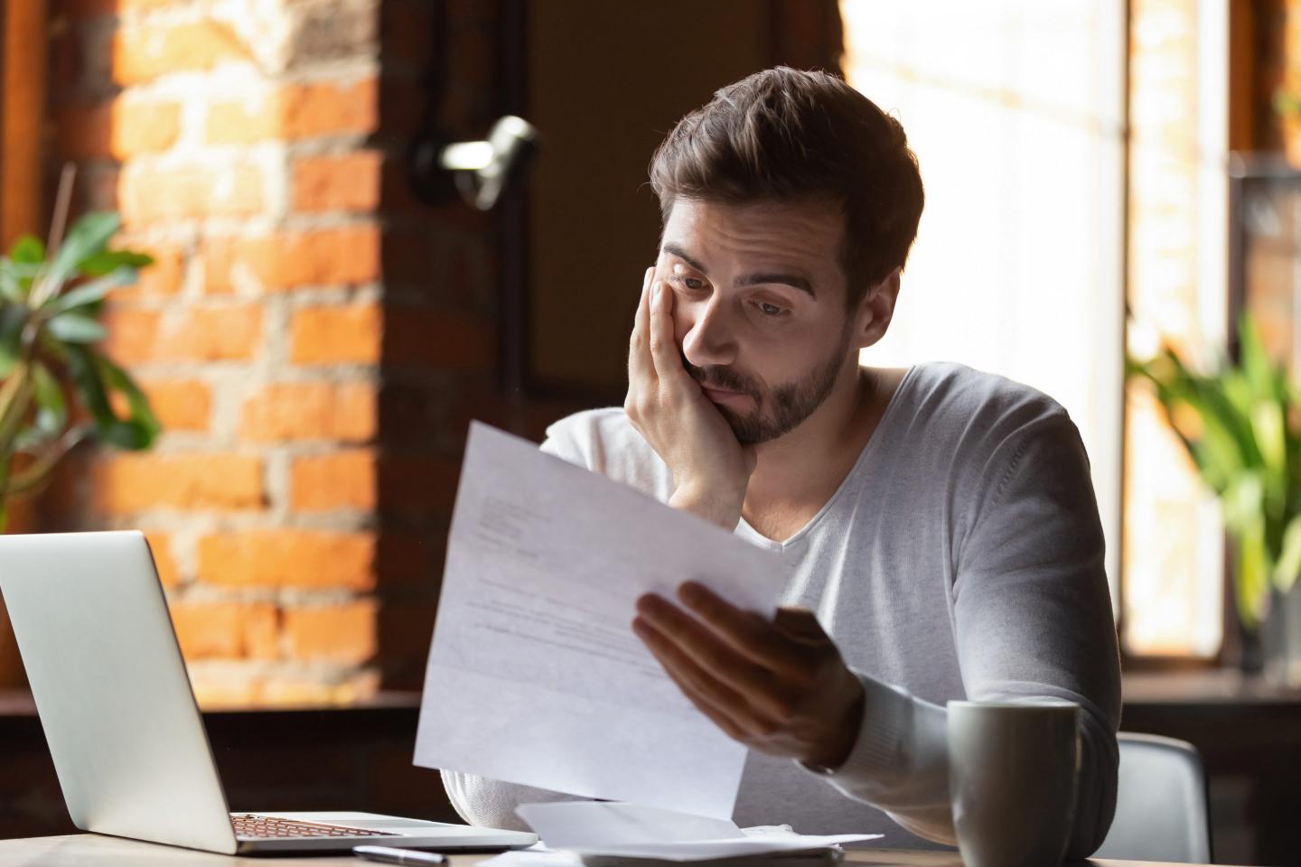 Frustrated young man reading letter